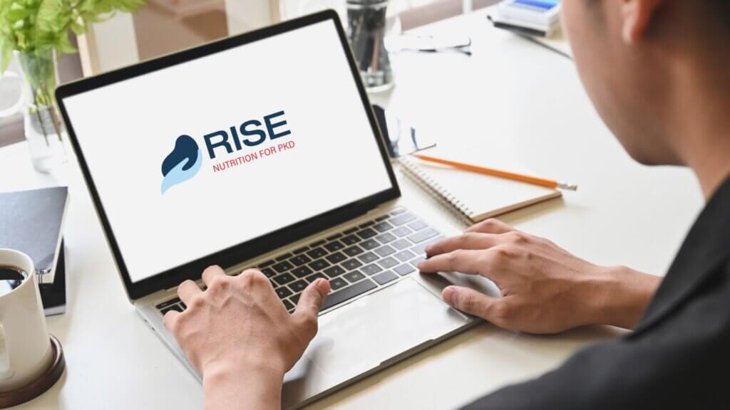 Wayne's Health Journey - Man on Laptop with RISE Logo